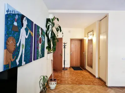 a hallway with paintings on the wall and a plant at ReHouse Stikliu 4 in Vilnius