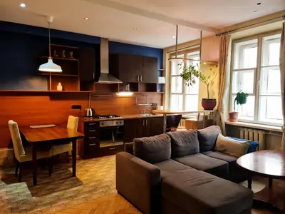 a living room and kitchen with a couch and a table at ReHouse Stikliu 4 in Vilnius