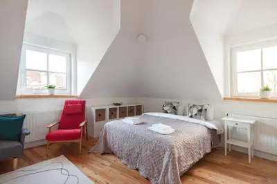 a bedroom with a bed and two red chairs at Pilies Street Exclusive Apartment by Reside Baltic in Vilnius