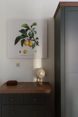 a dresser with a picture of a lemon tree on the wall at Pilies Street Exclusive Apartment by Reside Baltic in Vilnius