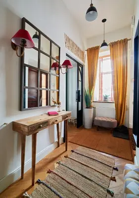 a living room with a wooden table and a mirror at Luxury OldTown Free Parking in Vilnius