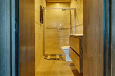 a bathroom with a toilet and a glass shower at Kaimo turizmo sodyba „Šerno slėnis“ in Vėdariai