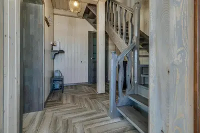 a hallway with wooden floors and stairs in a house at Kaimo turizmo sodyba „Šerno slėnis“ in Vėdariai