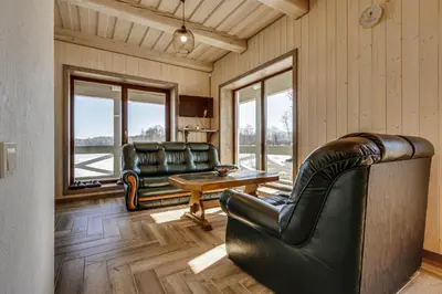 a living room with two leather chairs and a table at Kaimo turizmo sodyba „Šerno slėnis“ in Vėdariai