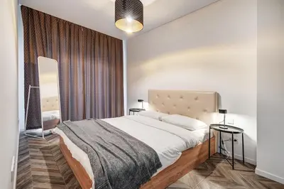 a bedroom with a large bed and a mirror at cohost I New Bastėja Life Apartments w-Garage Prkg & Self Check-in in Vilnius
