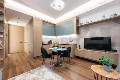 a living room with a table and chairs and a television at cohost I New Bastėja Life Apartments w-Garage Prkg & Self Check-in in Vilnius