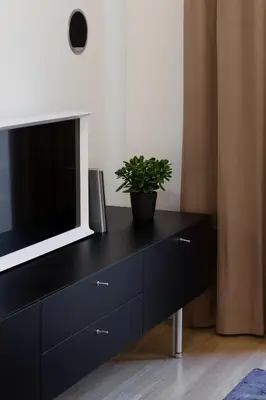 a black dresser with a tv and a plant on it at Design Studio Apartment with Balcony by Domvia in Kaunas