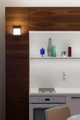 a kitchen with a white stove and a wooden cabinet at Design Studio Apartment with Balcony by Domvia in Kaunas