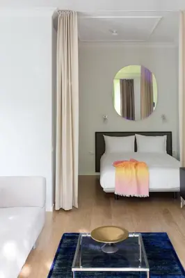 a bedroom with a bed and a couch and a table at Design Studio Apartment with Balcony by Domvia in Kaunas