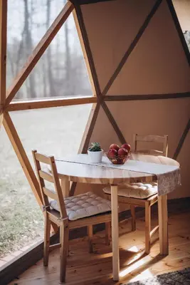 a table in a yurt with a bowl of fruit on it at VasaRojaus Kupolai in Birštonas