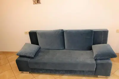 a blue couch with two pillows on top of it at Cozy apartment in Jeruzalė in Vilnius