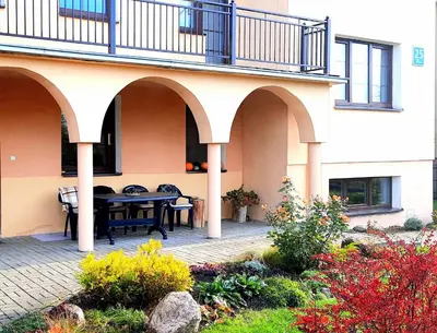 a patio with a table and a balcony at Šeimos Būstas Homestay in Šiauliai