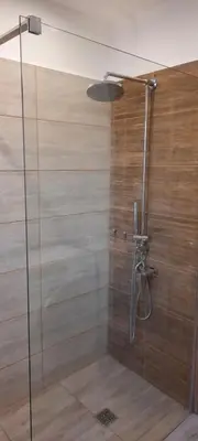 a shower with a glass door in a bathroom at Šeimos Būstas Homestay in Šiauliai