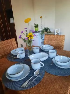 a table with blue and white dishes and spoons on it at Šeimos Būstas Homestay in Šiauliai