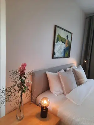 a bedroom with a couch and a vase with flowers on a table at Šeimos Būstas Homestay in Šiauliai