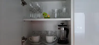a shelf with glasses and a coffee maker on it at Familia Apartments in Vilnius