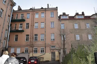 a large brick building with cars parked in front of it at Familia Apartments in Vilnius