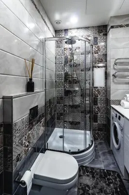 a bathroom with a shower and a toilet and a washing machine at Familia Apartments in Vilnius