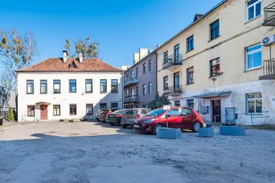 a group of cars parked in a parking lot next to buildings at Retro Studio Old Town Apartment by Domvia in Kaunas