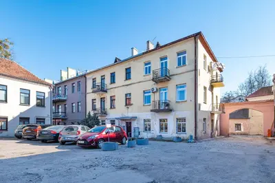 a large building with cars parked in a parking lot at Retro Studio Old Town Apartment by Domvia in Kaunas