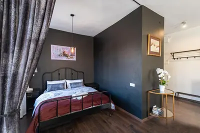 a bedroom with a bed and a black wall at Retro Studio Old Town Apartment by Domvia in Kaunas