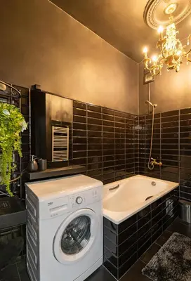 a bathroom with a washing machine and a tub at Retro Studio Old Town Apartment by Domvia in Kaunas
