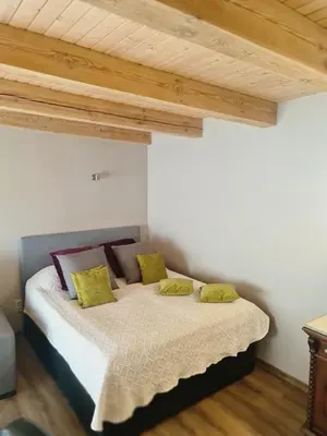 a bedroom with a bed with yellow and purple pillows at Sipis House in Šiauliai