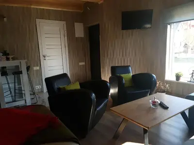 a living room with three chairs and a table at Sipis House in Šiauliai