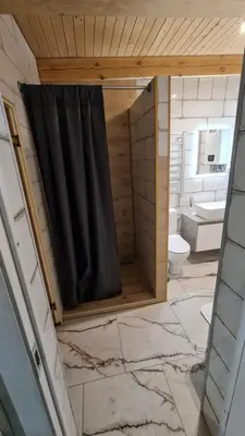 a bathroom with a black shower curtain and a toilet at Sipis House in Šiauliai