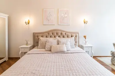 a bedroom with a large bed with two tables at E. D. Angel Wing Apartment in Šiauliai