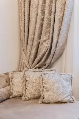 a curtain on a wall with two pillows at E. D. Angel Wing Apartment in Šiauliai