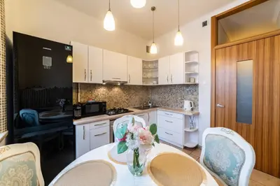 a kitchen with a table with a vase of flowers on it at E. D. Angel Wing Apartment in Šiauliai