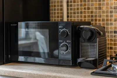 a microwave sitting on top of a counter at E. D. Angel Wing Apartment in Šiauliai