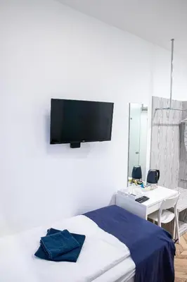 a bedroom with a bed with a tv on the wall at HOT SPOT Vilnius Apartments! in Vilnius