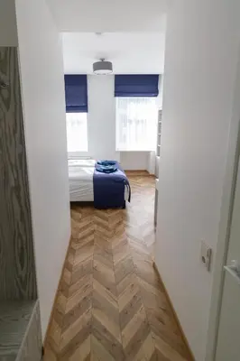 a hallway with a bed and a suitcase in a room at HOT SPOT Vilnius Apartments! in Vilnius