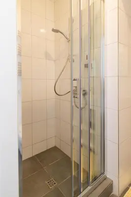 a shower with a glass door in a bathroom at HOT SPOT Vilnius Apartments! in Vilnius