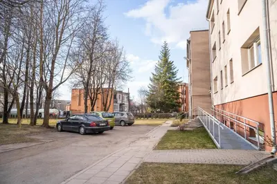 a car parked in a parking lot next to a building at Čia gera studio in Anykščiai