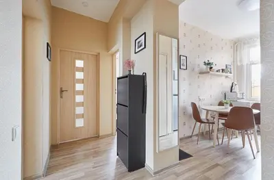 a kitchen and dining room with a refrigerator and a table at Kauko Laiptu Apartment in Kaunas