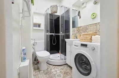 a bathroom with a washing machine and a toilet at Kauko Laiptu Apartment in Kaunas