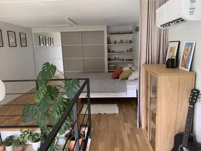 a living room with a bed and a guitar at Vilnius Cozy Loft in Vilnius