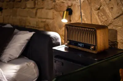 an old radio sitting on a table next to a bed at #stayhere - Historic Vilnius Old Town Chic Studio in Vilnius