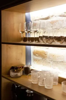 a shelf with wine glasses and baskets on it at #stayhere - Historic Vilnius Old Town Chic Studio in Vilnius