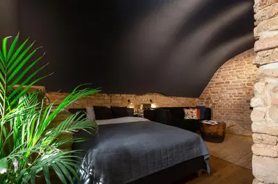 a bedroom with a bed and a brick wall at #stayhere - Historic Vilnius Old Town Chic Studio in Vilnius
