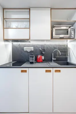 a kitchen with white cabinets and a sink at TopFloor Apartments in Vilnius