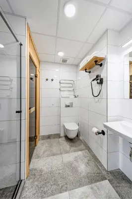 a white bathroom with a toilet and a sink at TopFloor Apartments in Vilnius