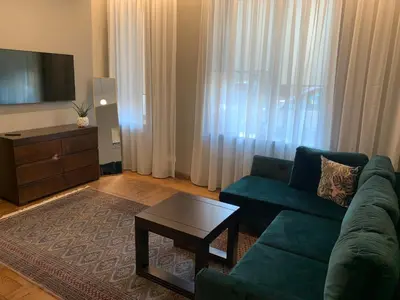 a living room with a green couch and a coffee table at Cathedral Apartments in Kaunas