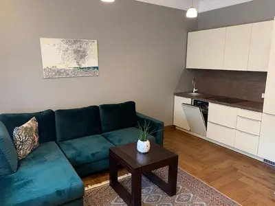 a living room with a blue couch and a table at Cathedral Apartments in Kaunas