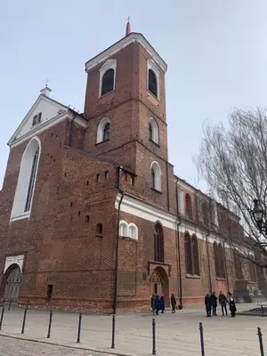 a large brick building with a clock tower at Cathedral Apartments in Kaunas