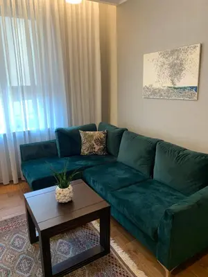 a living room with a green couch and a table at Cathedral Apartments in Kaunas