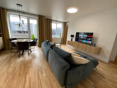 a living room with a couch and a table at Alėjos Apartmentai Comfort in Druskininkai